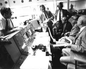 Deke Slayton shows the adapter devised during the Apollo 13 mission to make use of square Command Module lithium hydroxide canisters to remove excess carbon dioxide from the Apollo 13 LM cabin