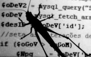 A photo of a grashopper crawling across a screen of computer code. Applied to software design and programming, Murphy's Law can prevent bugs being introduced into code.