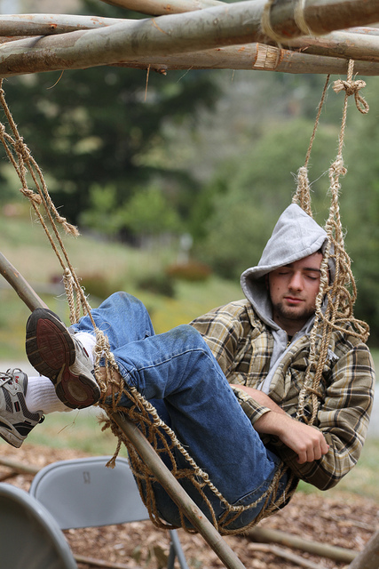 Young man in a very uncomfortable hammock, pretending to have a REST.