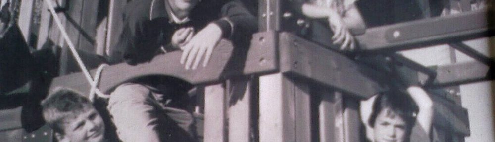 Black and white photo of four kids on an outdoor cubby house