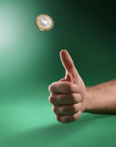 A hand flipping a coin