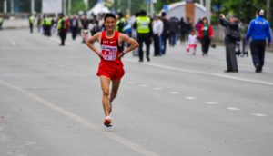 Tired marathon runner with hands on hips