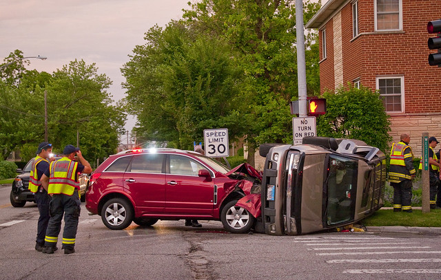 A side-collision car crash at an intersection, surrounded by emergency personnel. Like this, merge conflicts can be messy and dangerous.